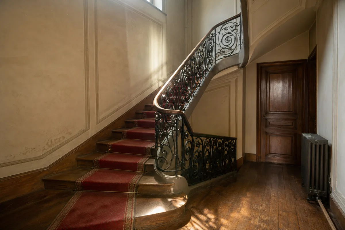 Cage d’escalier ancienne d’un immeuble parisien avec rampe en fer forgé